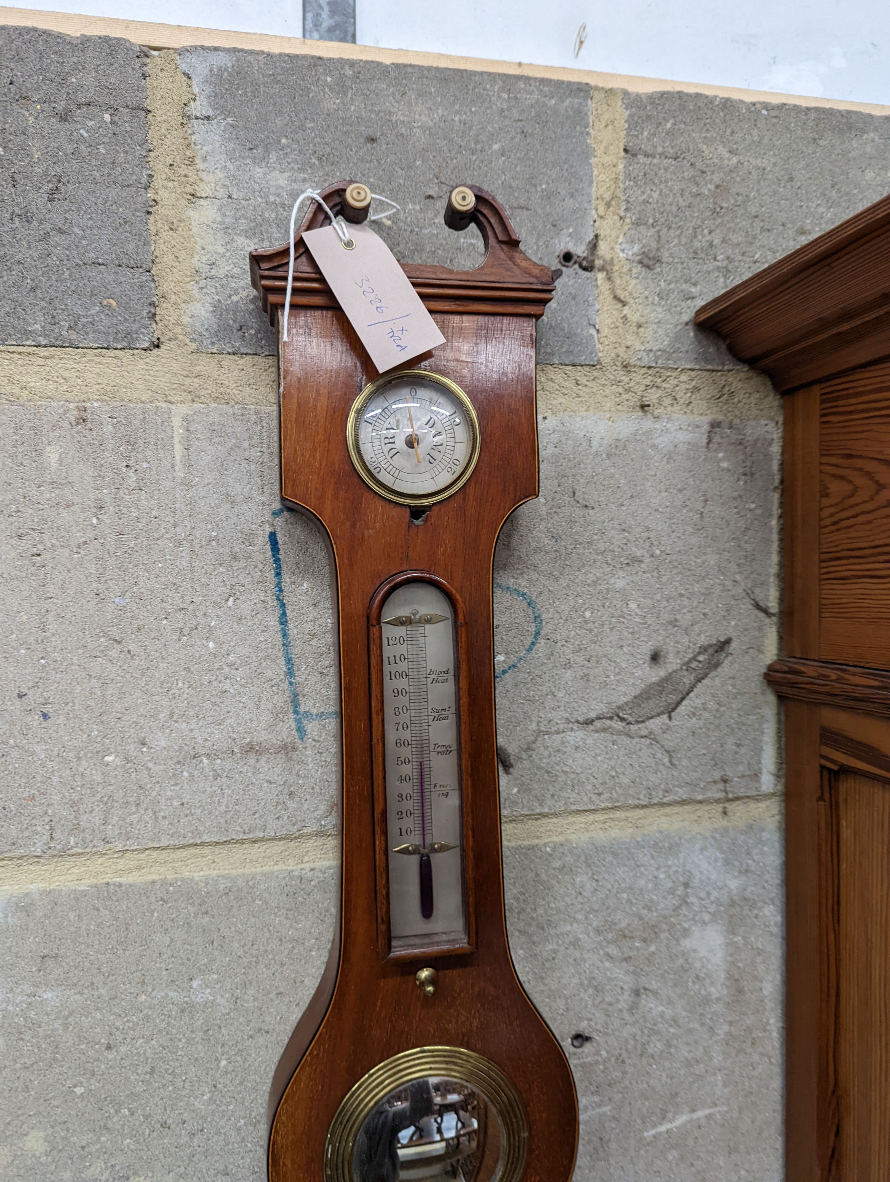 A mahogany wheel barometer. Length -107cm, W-32cm.